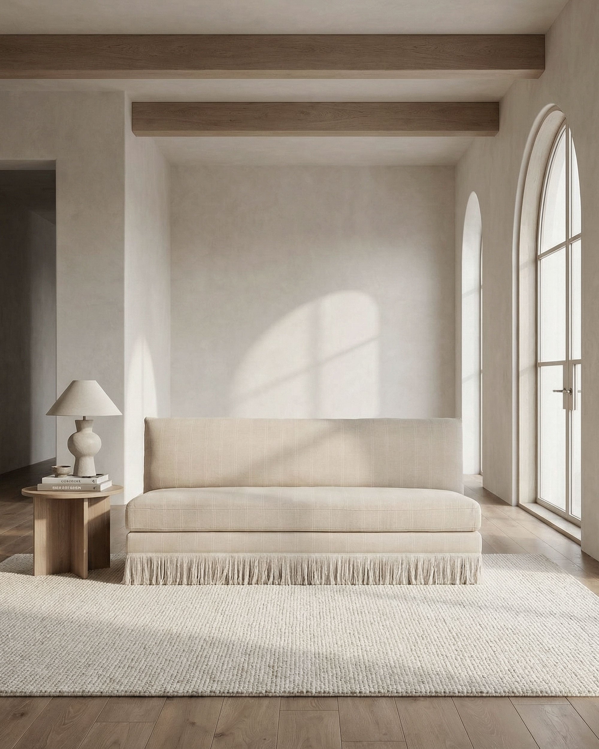 Beige sofa in a minimalistic room with large windows and wooden beams.