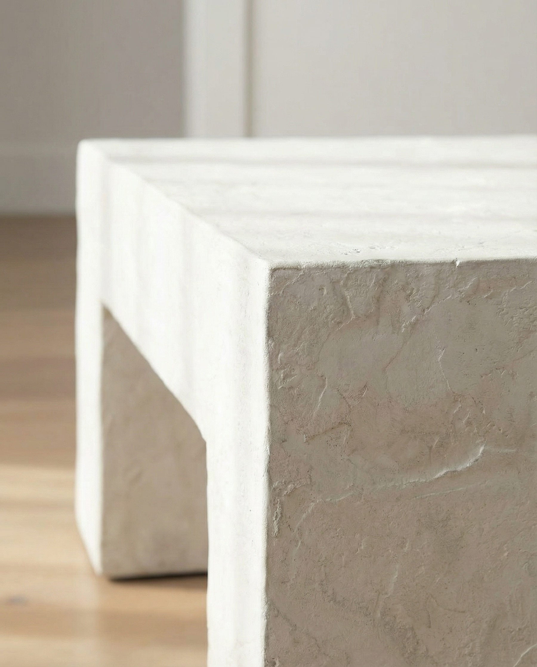 Close-up of a white plaster coffee table with a gray concrete base.