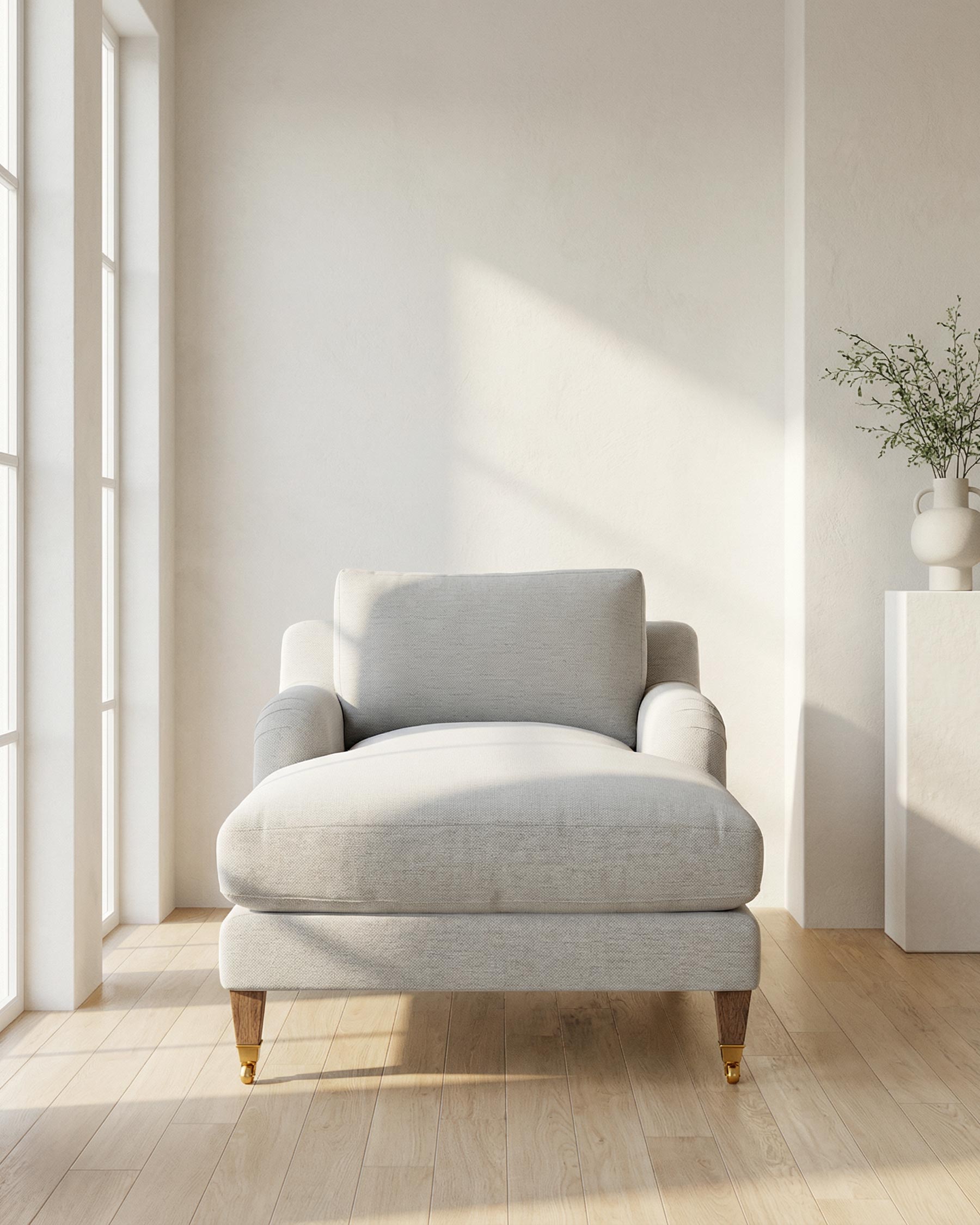 Gray armchair in a bright room with large windows and minimal decor.