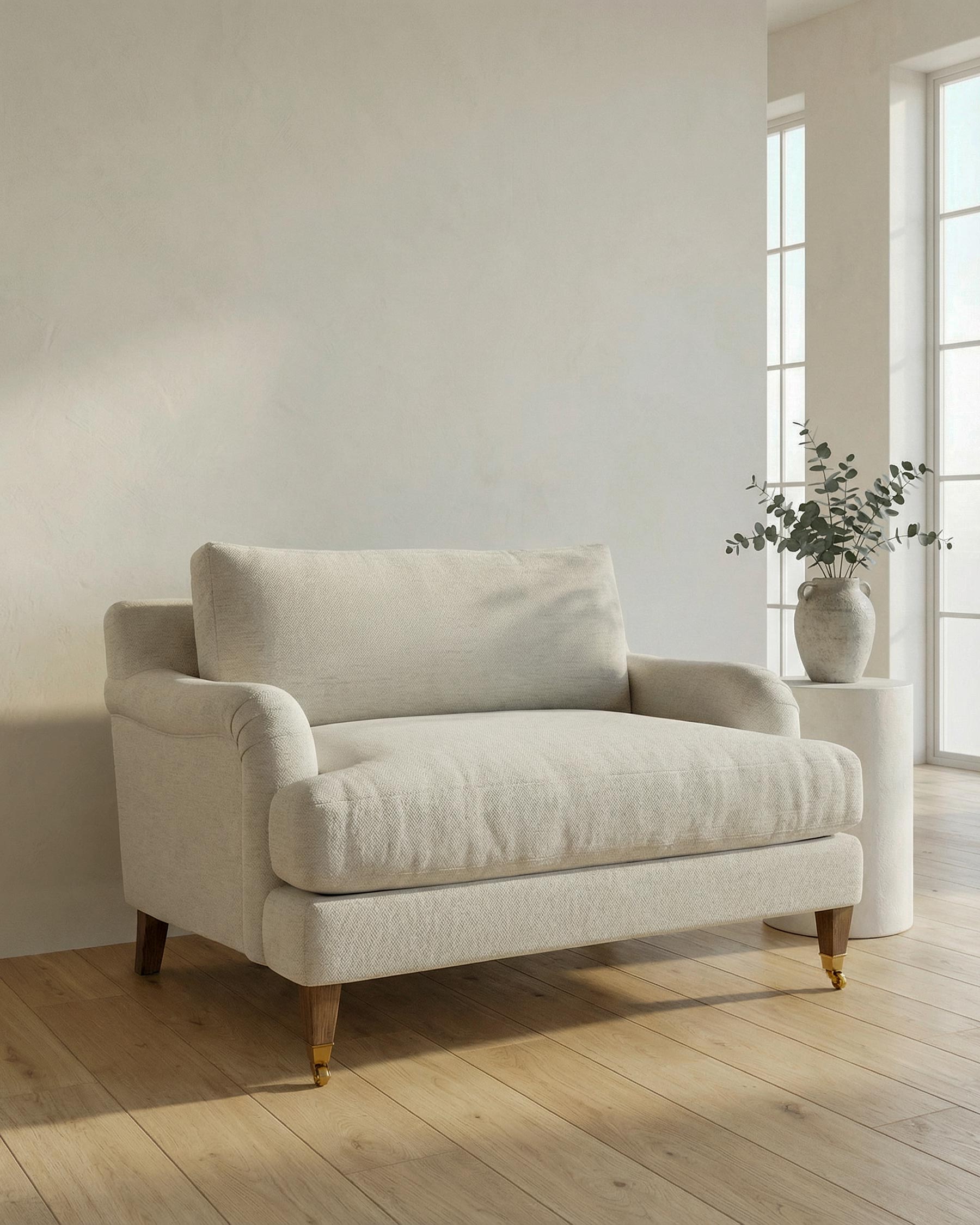 Beige sofa in a bright room with large windows and a vase of plants.